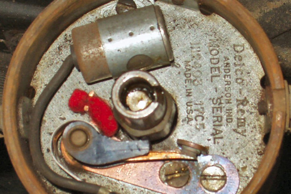 Close-up of a points-type distributor. You can barely see the rubber nub riding on the distributor shaft cam with the points closed. Counting the cam lobes, you can see this is from a six cylinder engine.