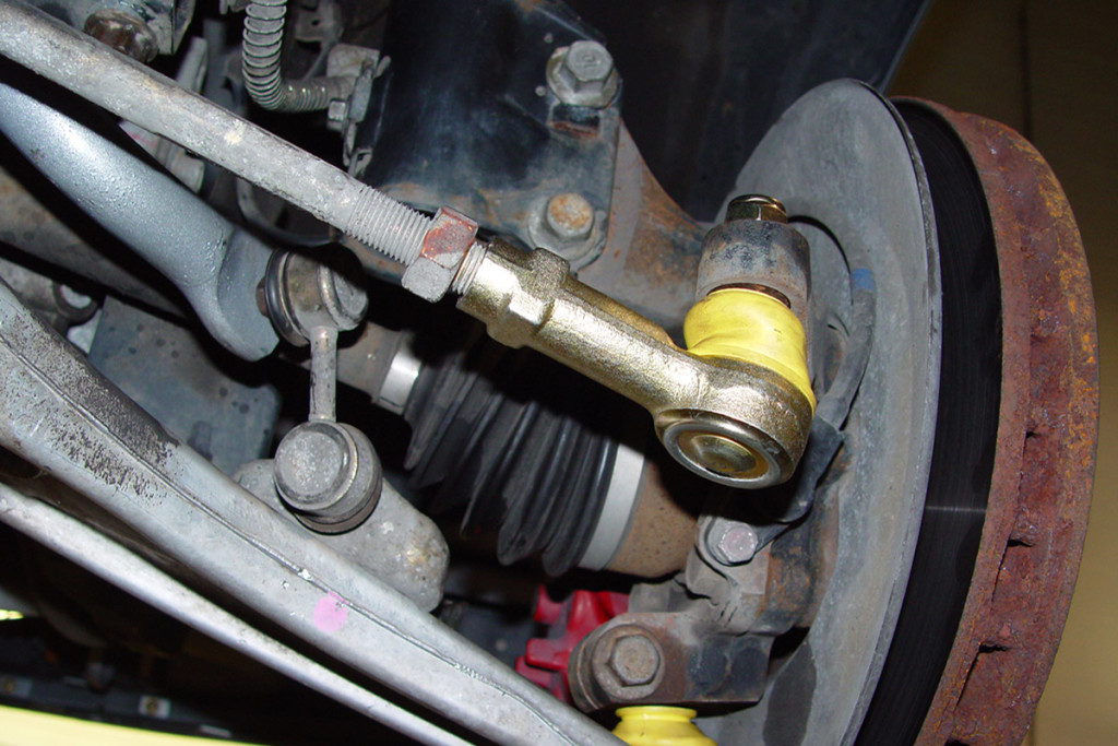 This image shows the outer tie rod end and inner rod connection arm on a Dodge Viper. The tie rod locknut has some red paint on it and is shown loose so the toe can be adjusted.