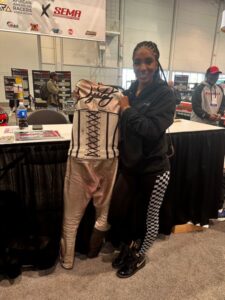 Motorcycle drag racer Destiny Spurlock at the "Still I Race" booth at SEMA 2022 celebrating the often overlooked legacy of black racers in the industry.